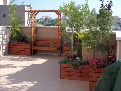 שילוב ספסל ישיבה וסולמות הדלייה במערכת אדניות וצמחיה בגג ברעננה